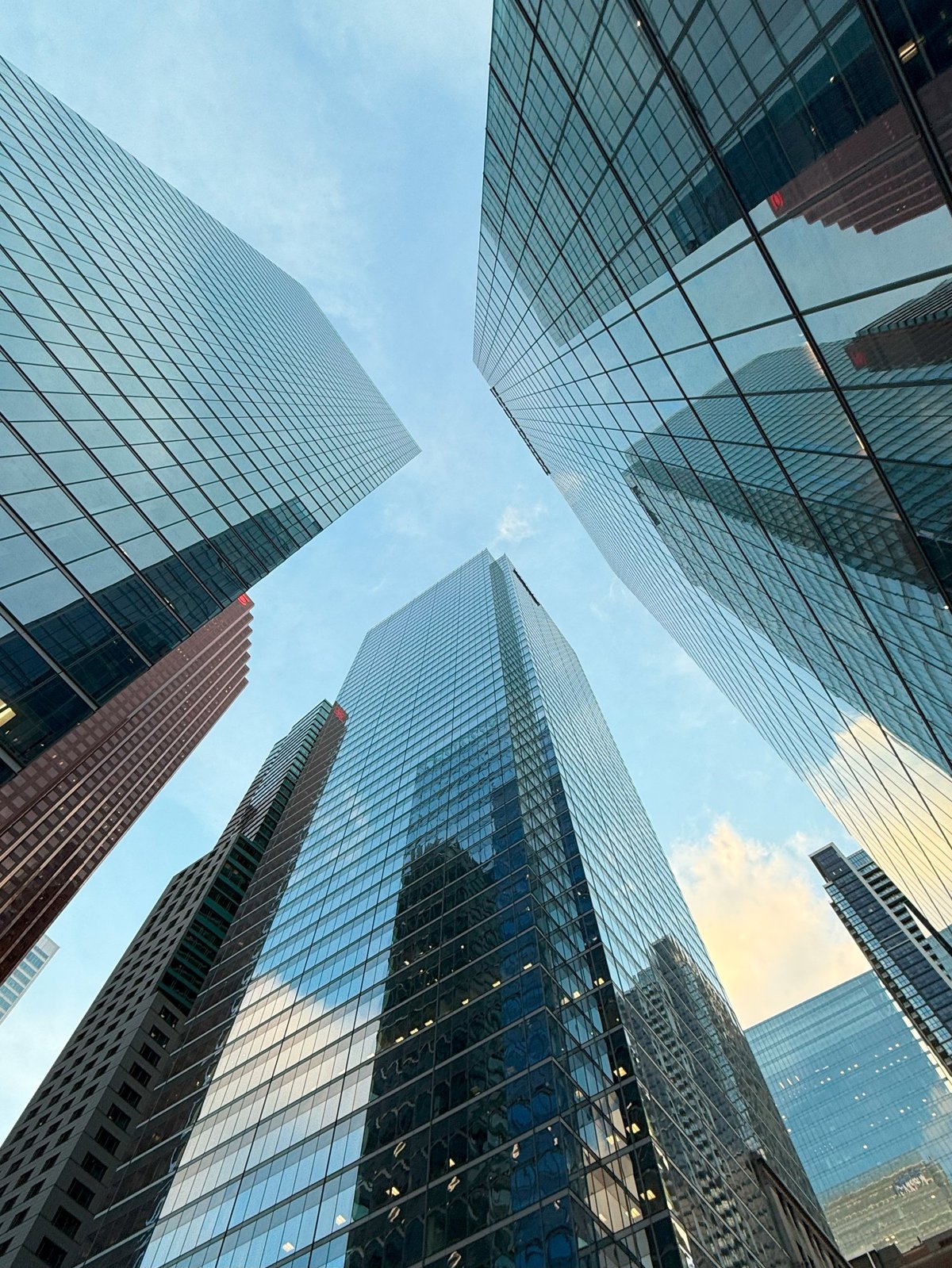 Low angle view of modern glass skyscrapers reflecting the sky