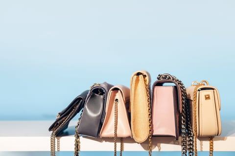Minimal fashion scene with multiple small handbags placed in a row